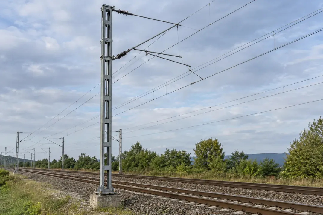Railway catenary support mast, base and overhead contact wires.