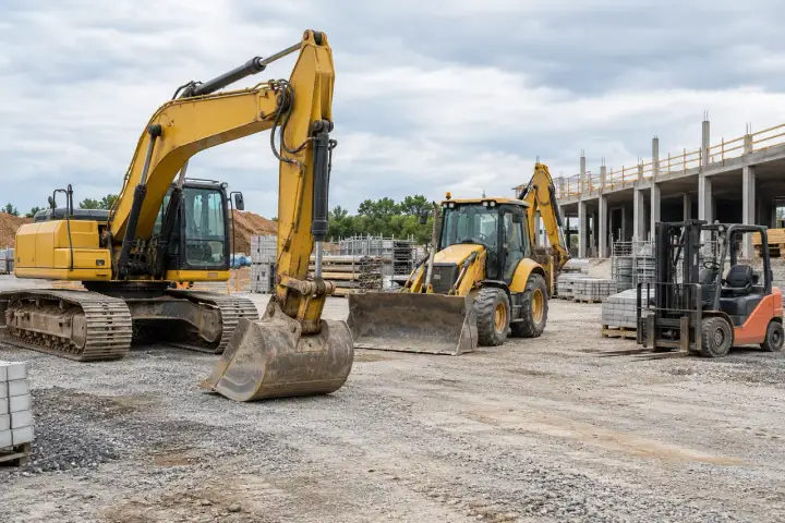 Excavators and loaders parked in a construction equipment yard