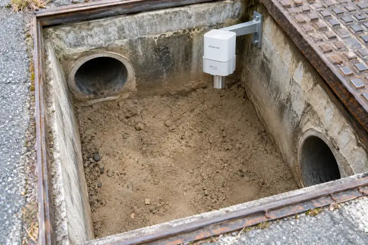 Concept installation of a Hitelecom radar sensor facing exposed dry sediment in a concrete catchpit.