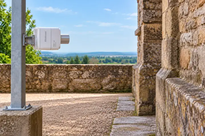 Horizontally rotated Hitelecom radar sensor on an independent post facing a protected stone wall