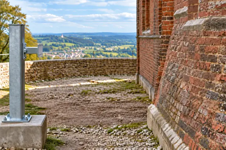 Historic tower movement references installation background: The actual broad brick buttress face or a tower-attached target opposite the independent reference.