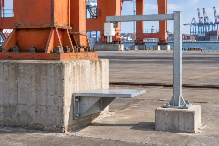 Hitelecom radar on a separate reference arm facing a broad target on a port gantry foundation; concept installation