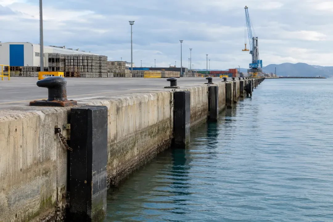 Concrete quay wall and working apron along an operating port.