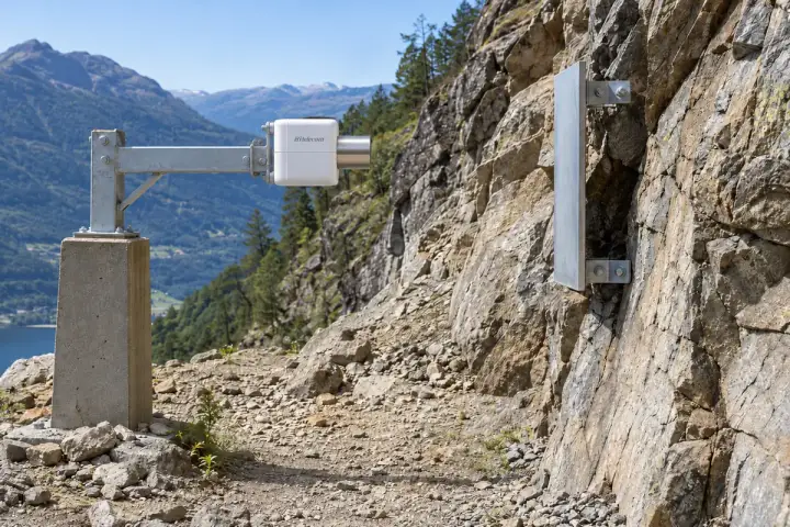 Hitelecom radar sensor mounted sideways on an independent reference, facing an anchored rock-slope target, illustrative installation