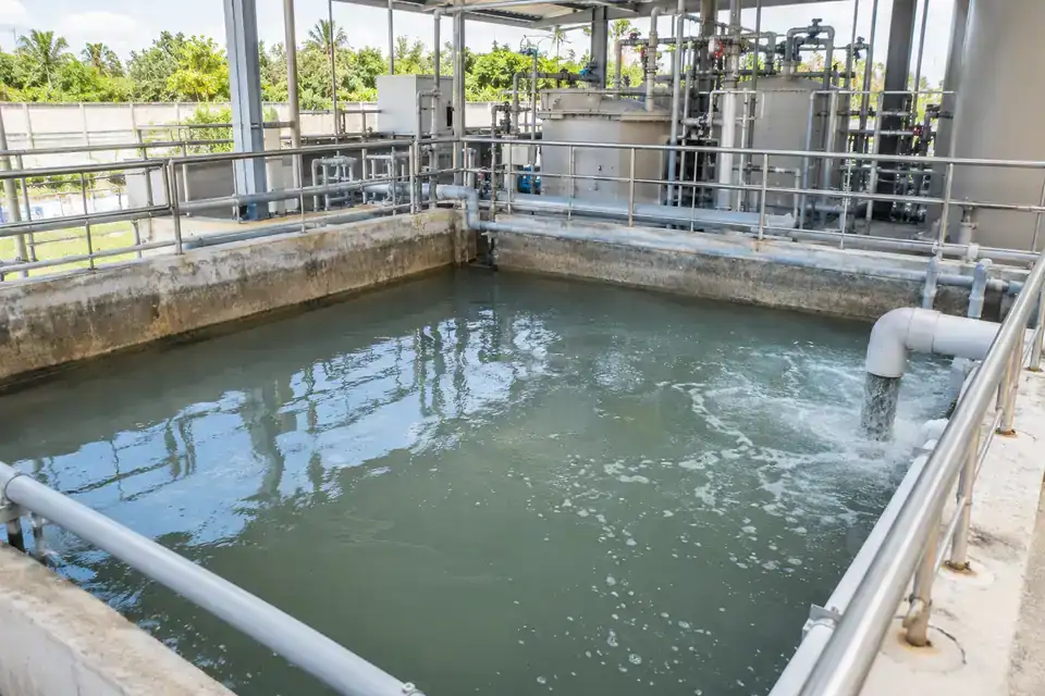 Wastewater neutralization-treatment collection area with containment, liquid tank and dosing equipment in the background
