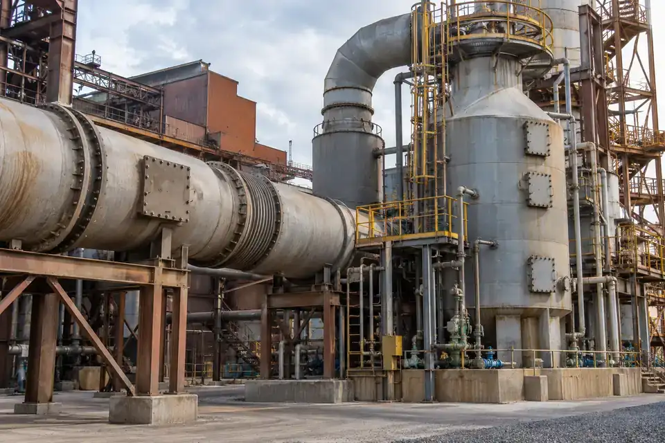 Metal smelter sulfur-gas service area with process ductwork, treatment equipment and an industrial maintenance platform