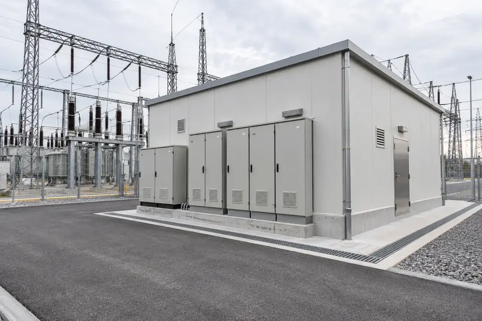 Substation auxiliary building with closed control cabinets and an external drainage channel