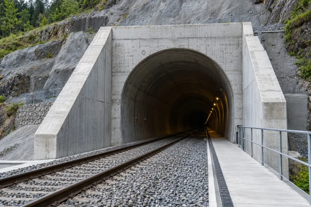 Tunnel portal with concrete headwall and engineered support structures.