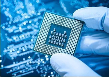 Gloved hand holding a processor chip over a circuit board